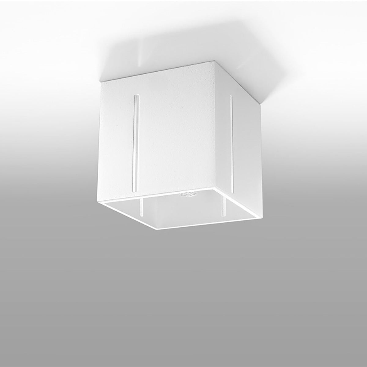 Plafonnier blanc installé au plafond, légèrement incliné, sur fond gris dégradé.