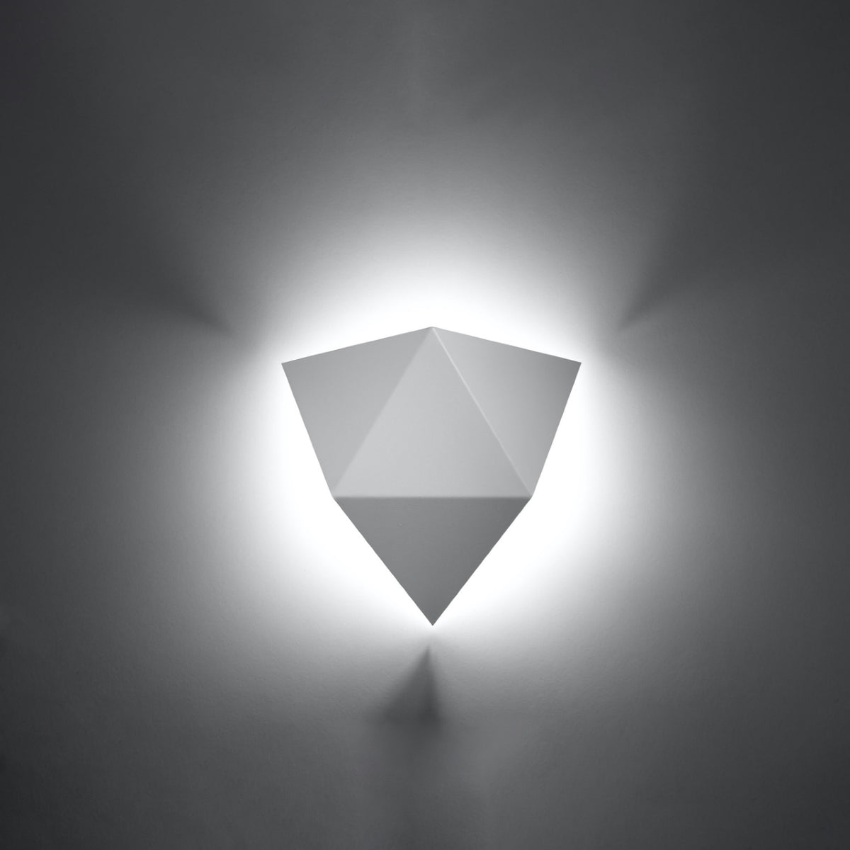 Applique allumée sur un mur sombre, halo lumineux diffus autour de la silhouette