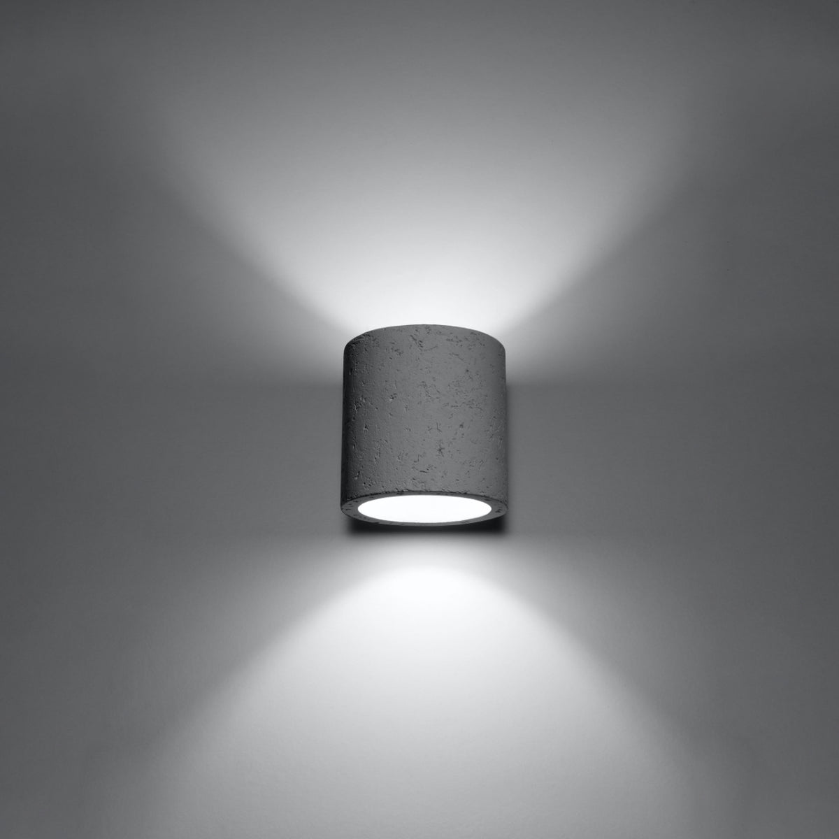 Applique allumée diffusant deux faisceaux lumineux verticaux sur mur gris