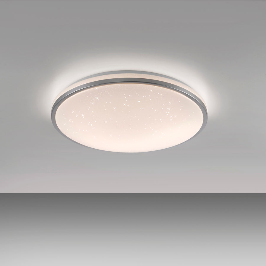 Plafonnier circulaire allumé au plafond, halo lumineux et ciel étoilé.