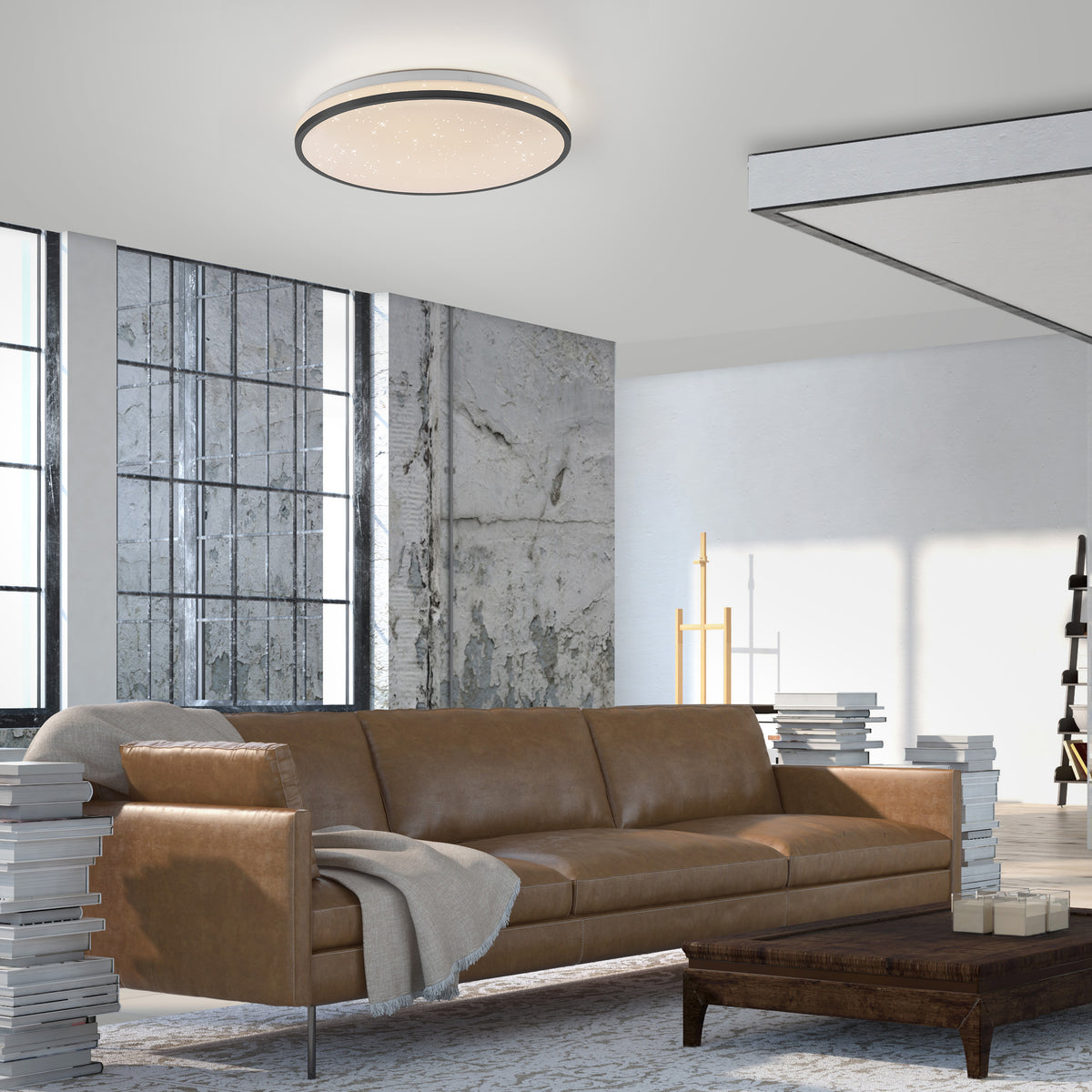 Mise en ambiance dans un salon loft, plafonnier allumé au-dessus d'un canapé en cuir