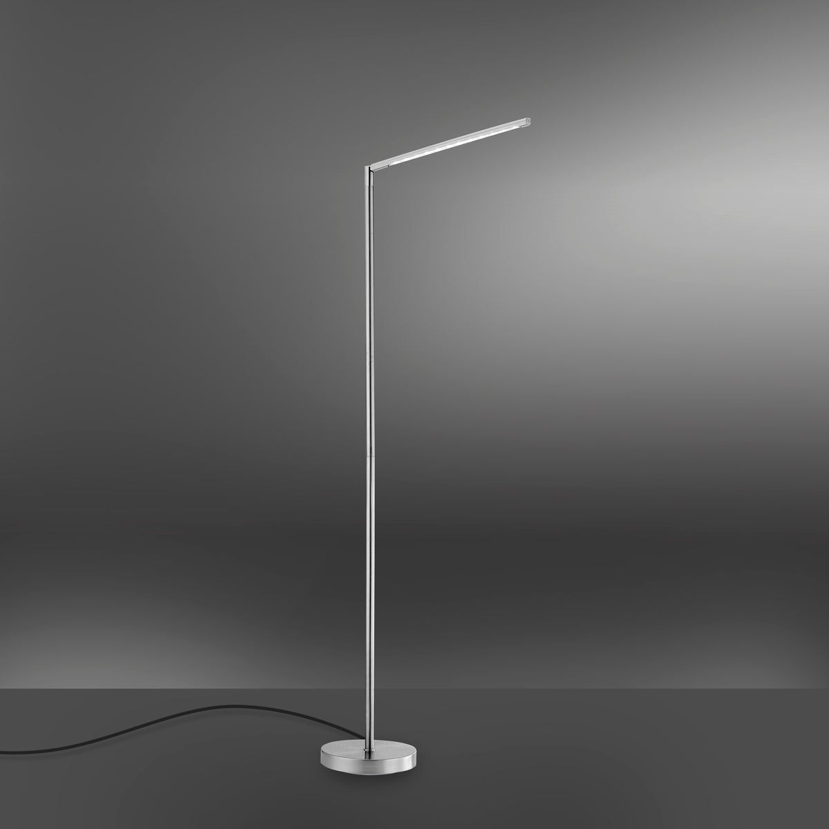 Lampadaire argenté sur fond dégradé gris, câble noir visible au sol.