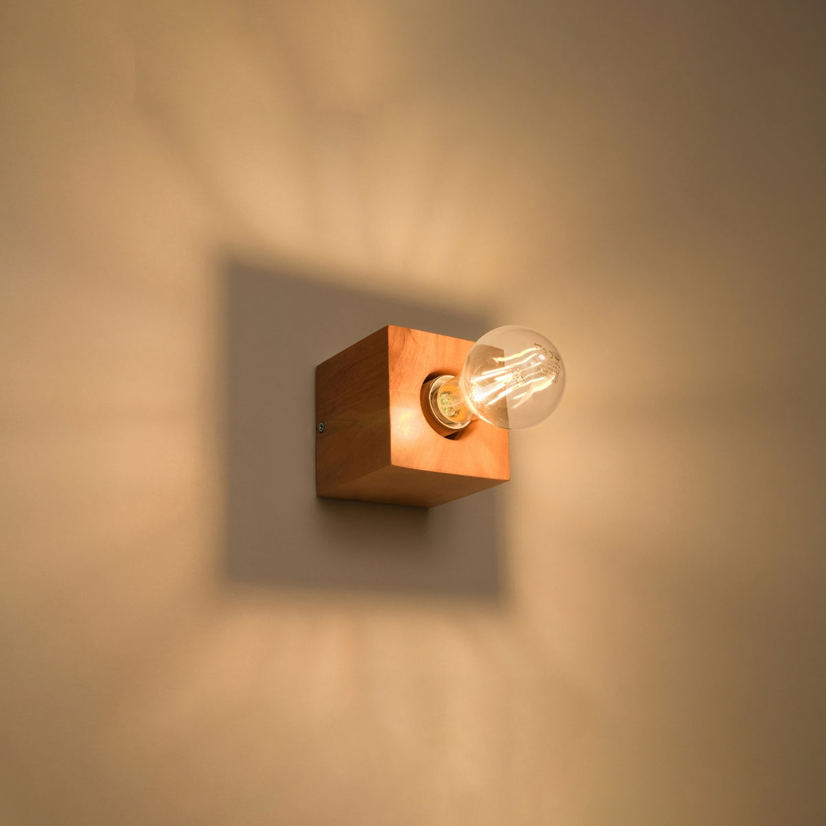 Mise en ambiance nocturne, halo chaud projeté par le cube en bois sur le mur