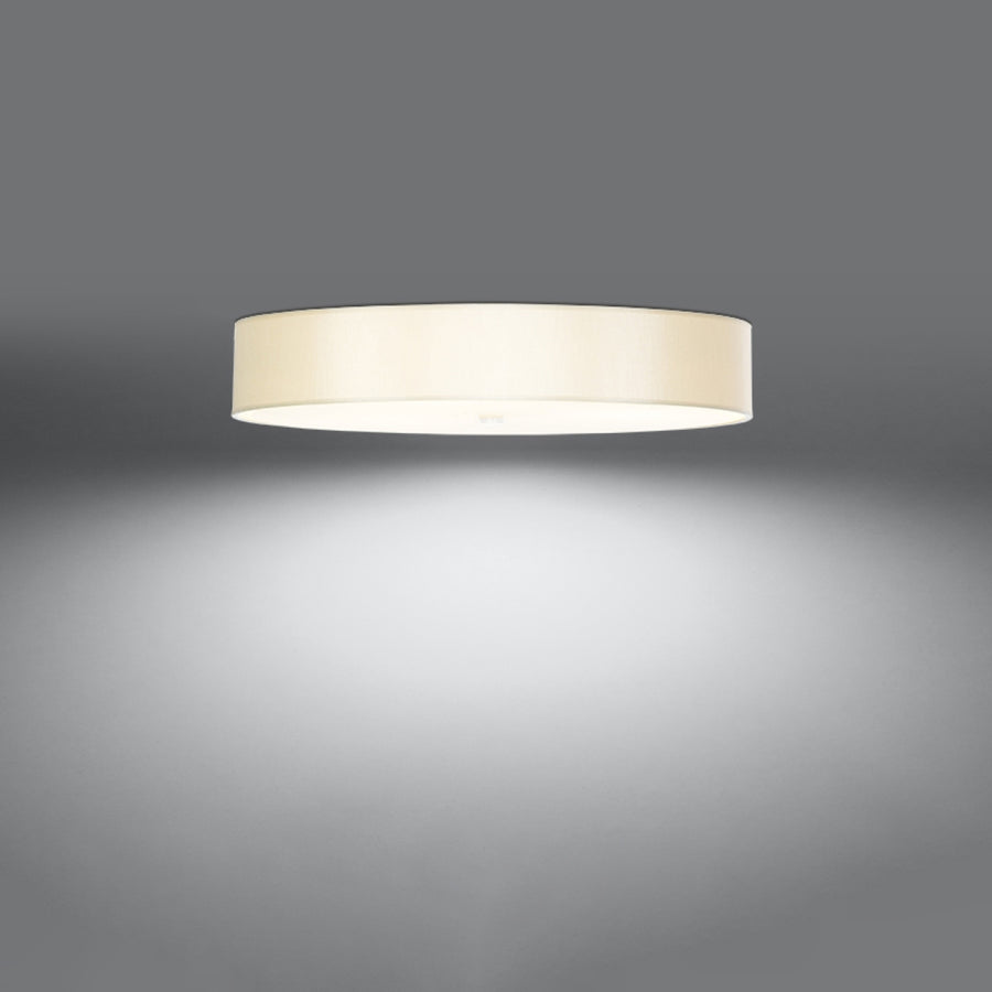 Plafonnier allumé dans une pièce sombre, halo de lumière blanche diffusée