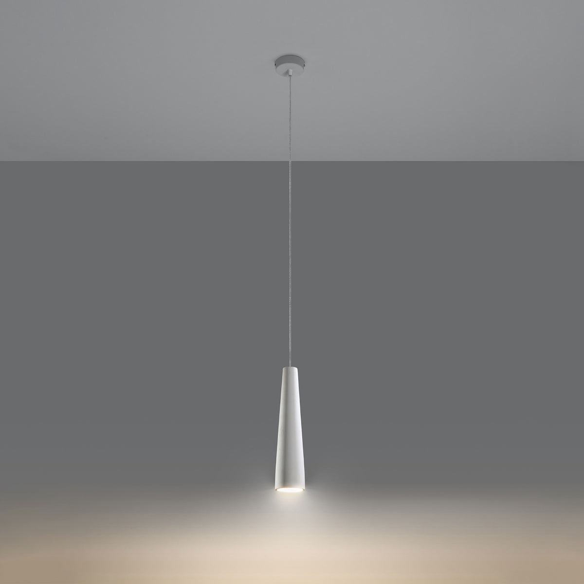 Lampe allumée projetant un halo de lumière chaude vers le bas sur le sol