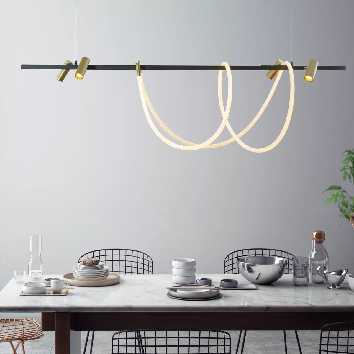 Mise en ambiance au-dessus d'une table à manger avec assiettes et chaises noires.