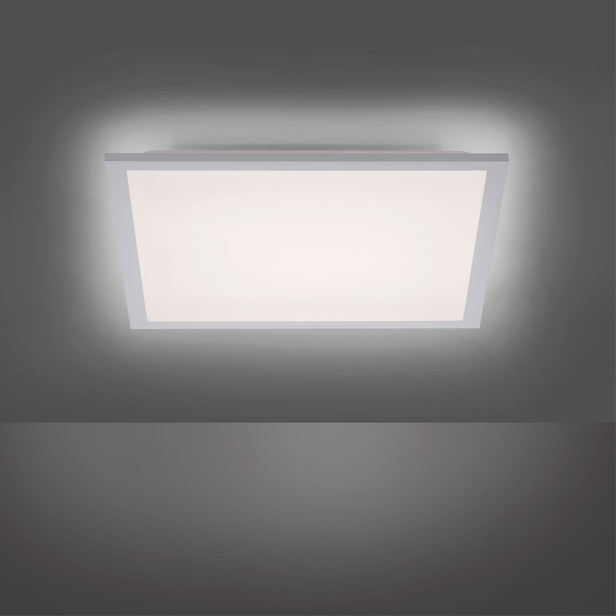 Halo lumineux diffusé par le panneau blanc allumé dans une pièce sombre