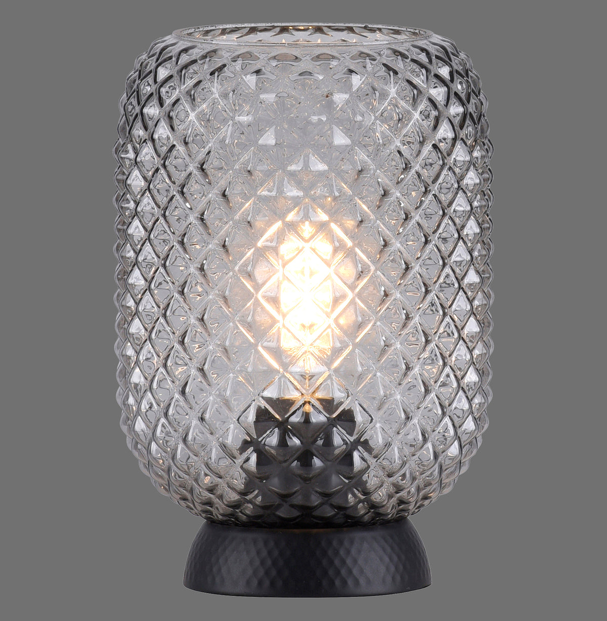 Lampe à poser en verre fumée allumée, vue de face sur fond gris.