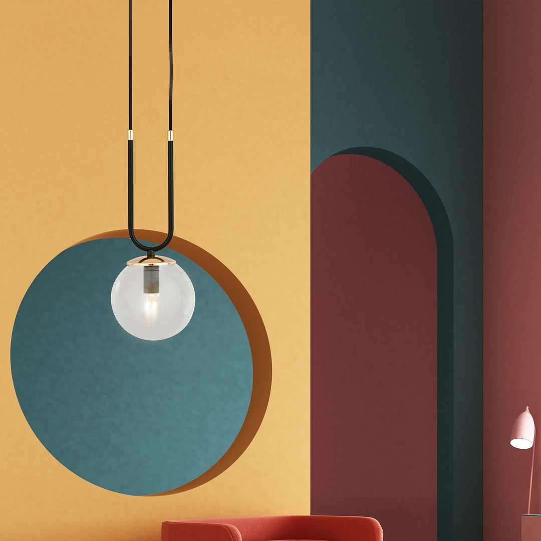 Ambiance colorée avec le luminaire suspendu devant un mur jaune, cercle bleu et arche bordeaux.