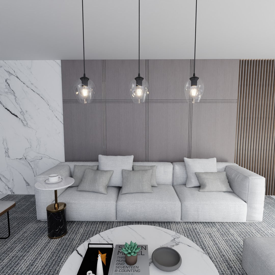 Trois suspensions noires dans un salon contemporain, mur gris et canapé clair