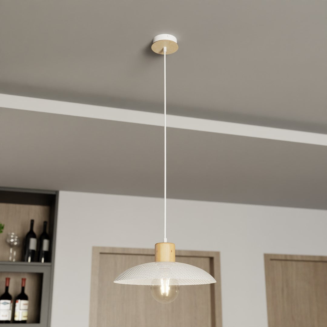 Gros plan sur l'abat-jour perforé et l'ampoule chaude du luminaire suspendu au plafond.