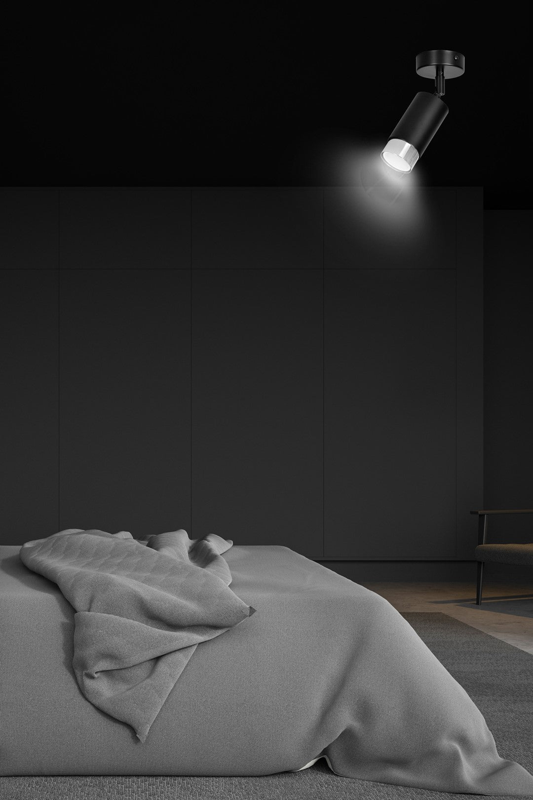 Mise en ambiance dans une chambre sombre, spot orienté vers le lit