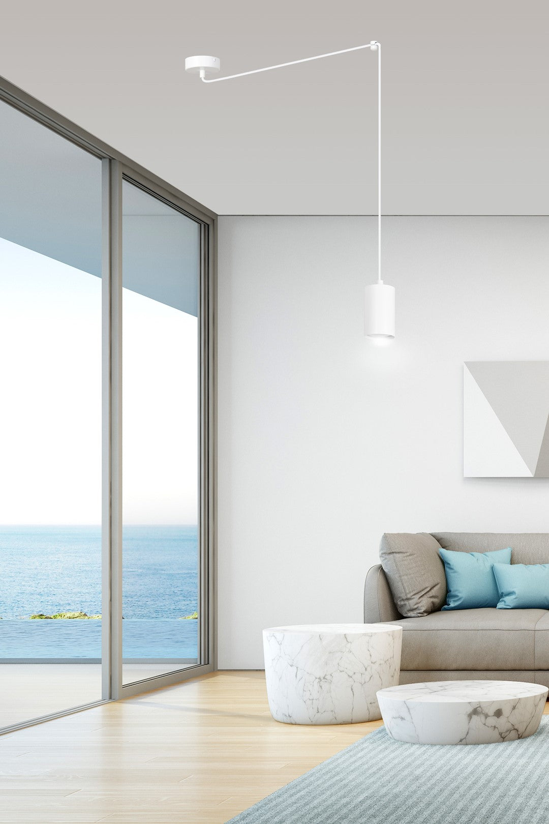 Mise en ambiance dans un salon bord de mer, suspension blanche au-dessus du canapé.