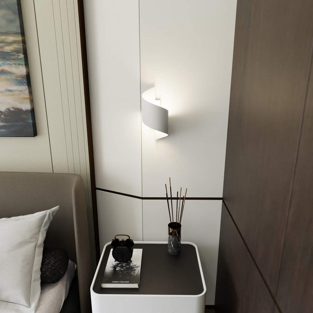 Ambiance de chambre avec applique murale allumée au-dessus de la table de nuit.