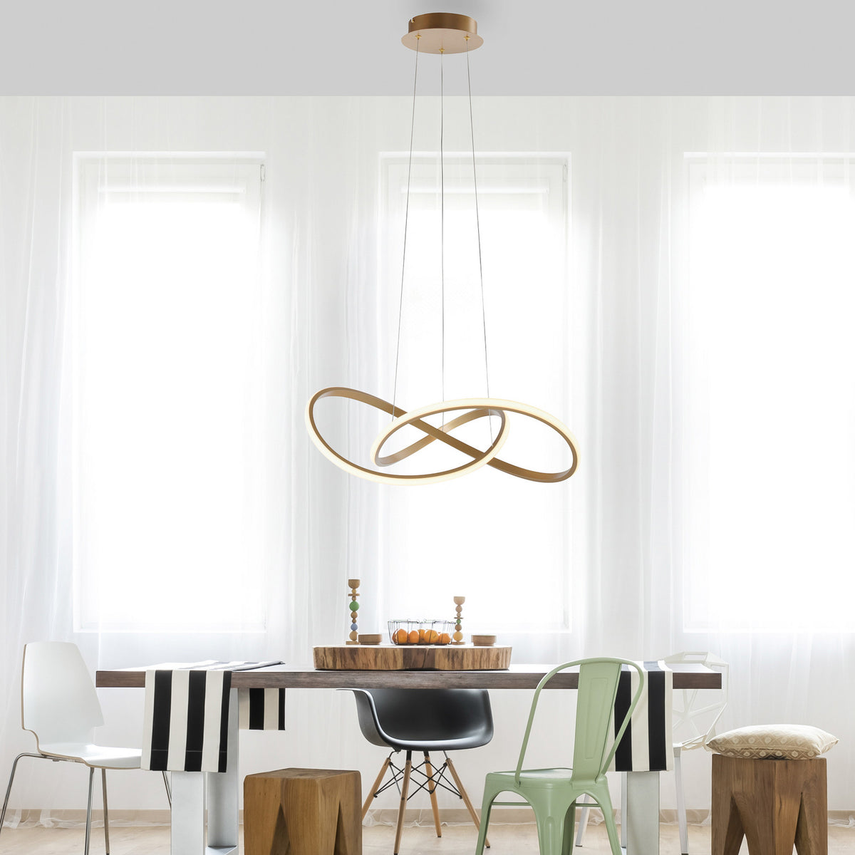 Mise en ambiance au-dessus d’une table à manger, suspension dorée à anneaux lumineux