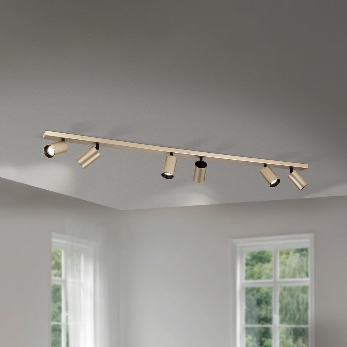 Plafonnier doré à six projecteurs orientables fixé au plafond dans une pièce claire