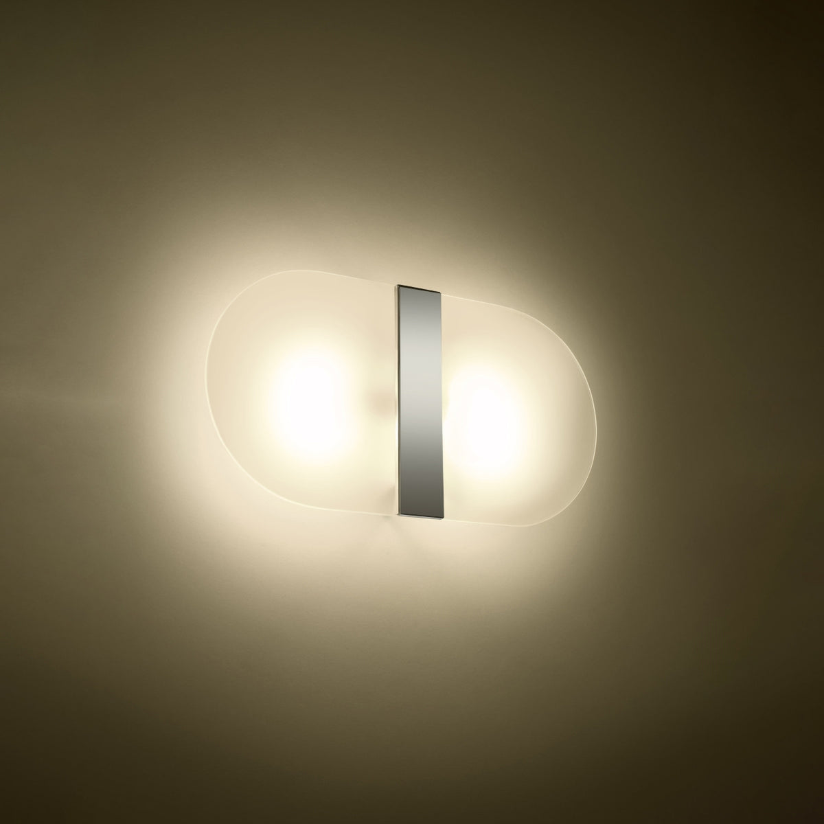 Mise en ambiance nocturne, halo lumineux chaud diffusé sur le mur sombre