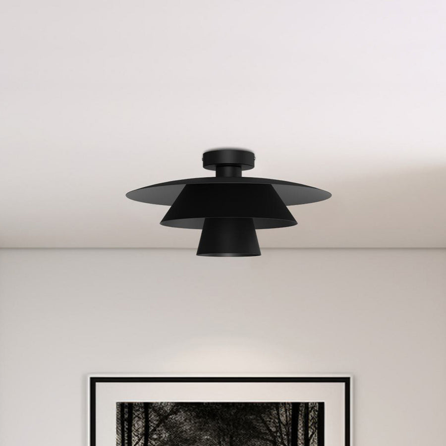 Plafonnier noir fixé au plafond au-dessus d'une œuvre encadrée