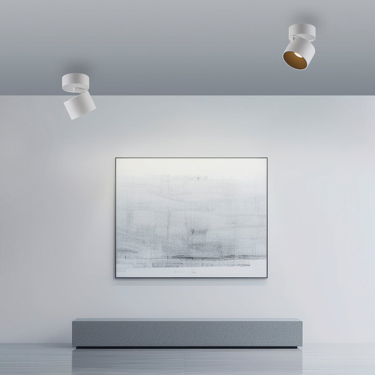 Deux spots blancs fixés au plafond éclairent un tableau abstrait dans un salon.