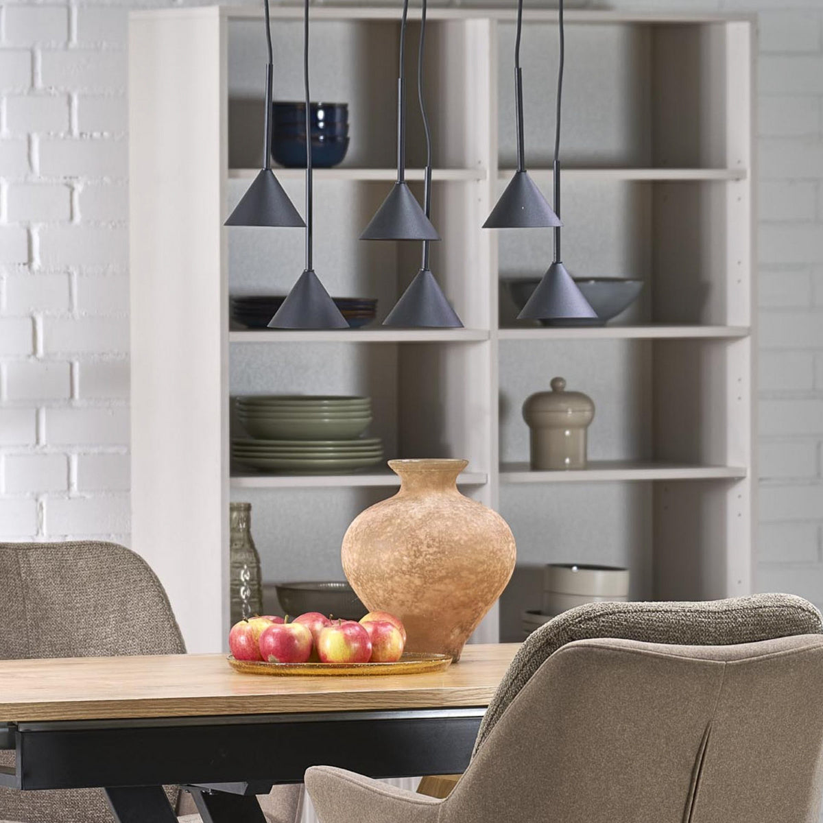Suspension noire à six cônes installée au-dessus d'une table en bois dans une salle à manger.