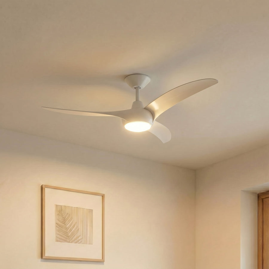 Vue de trois quarts d'un ventilateur de plafond blanc allumé, suspendu dans une pièce meublée.