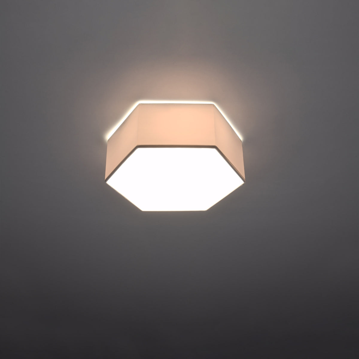 Module hexagonal allumé dans une pièce sombre, halo lumineux diffus