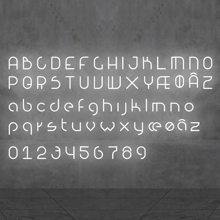 Alphabet complet et chiffres lumineux blancs disposés sur une paroi grise.