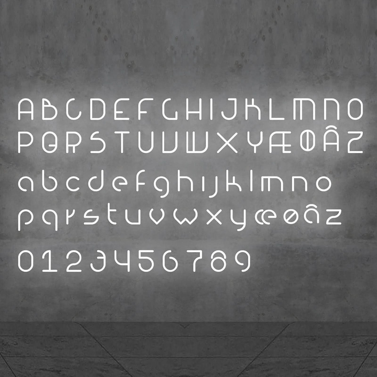 Alphabet complet lumineux en lettres blanches et chiffres, présenté de face sur fond gris.