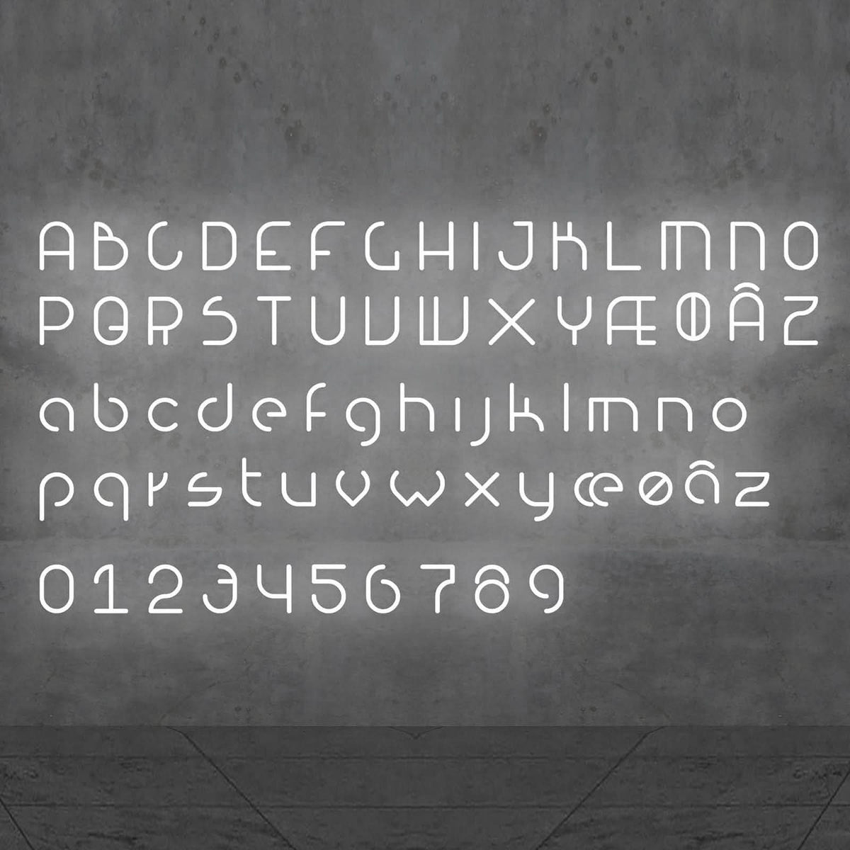 Alphabet complet de lettres et chiffres lumineux blancs présenté sur un mur gris.