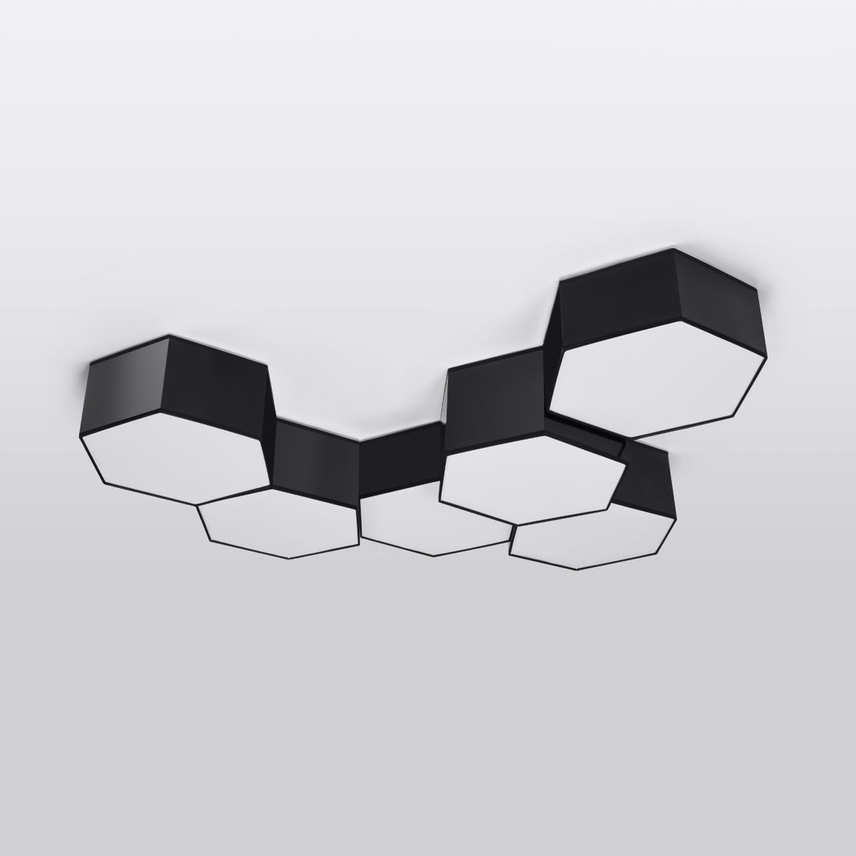 Grappe de plafonniers hexagonaux noirs installée au plafond, vue de biais