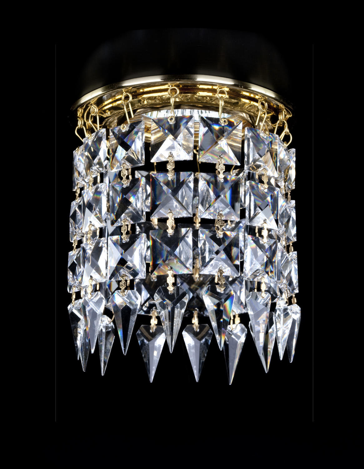 Vue de face du luminaire en cristal doré avec pampilles étagées sur fond noir.