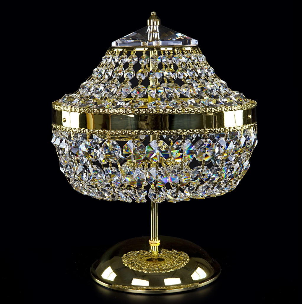 Lampe à poser dorée à abat-jour de cristaux taillés, présentée de face sur fond noir.