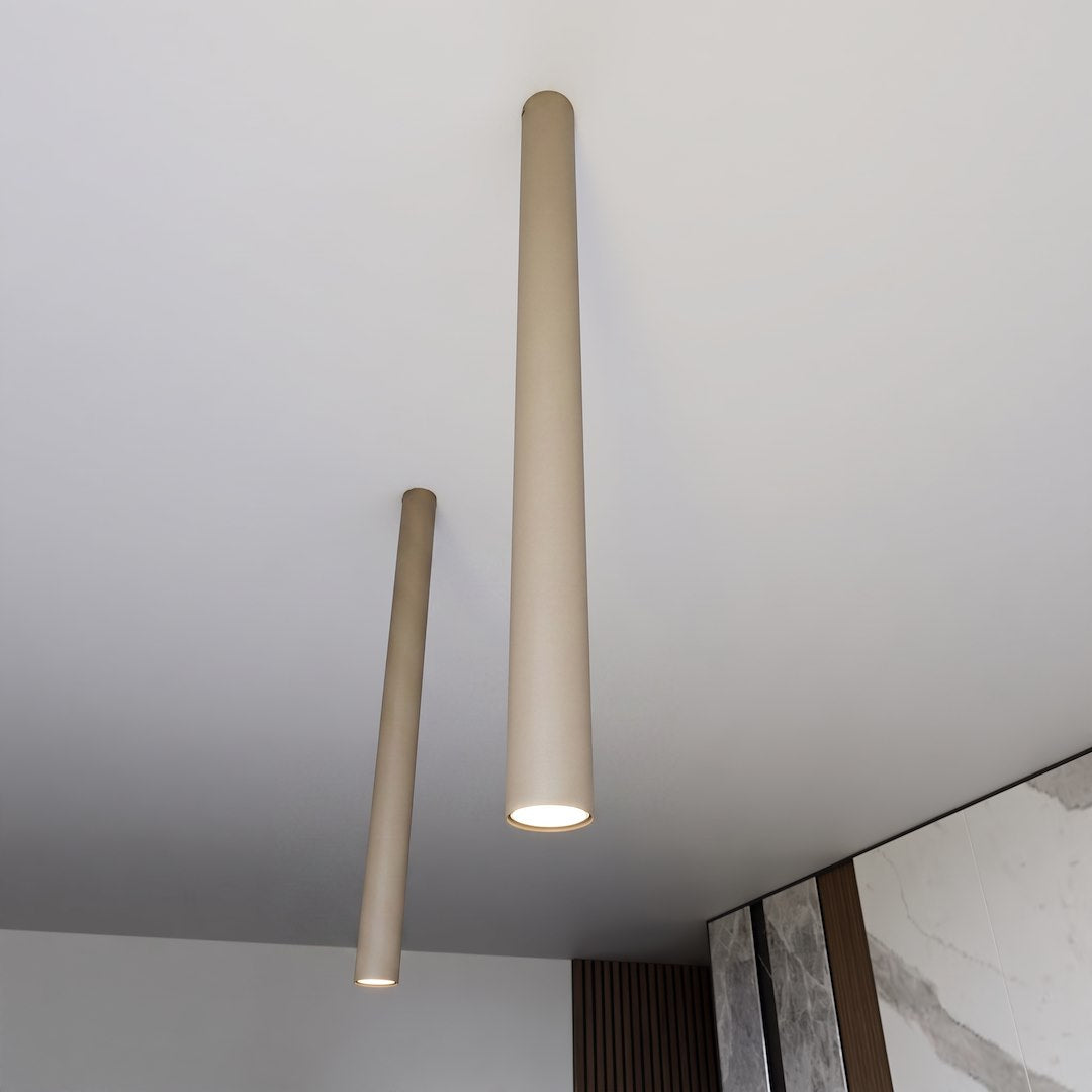 Deux tubes beige fixés au plafond dans un intérieur contemporain avec marbre.