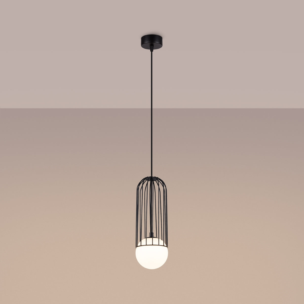 Luminaire suspendu allumé sur fond beige, halo chaud sous le globe opalin