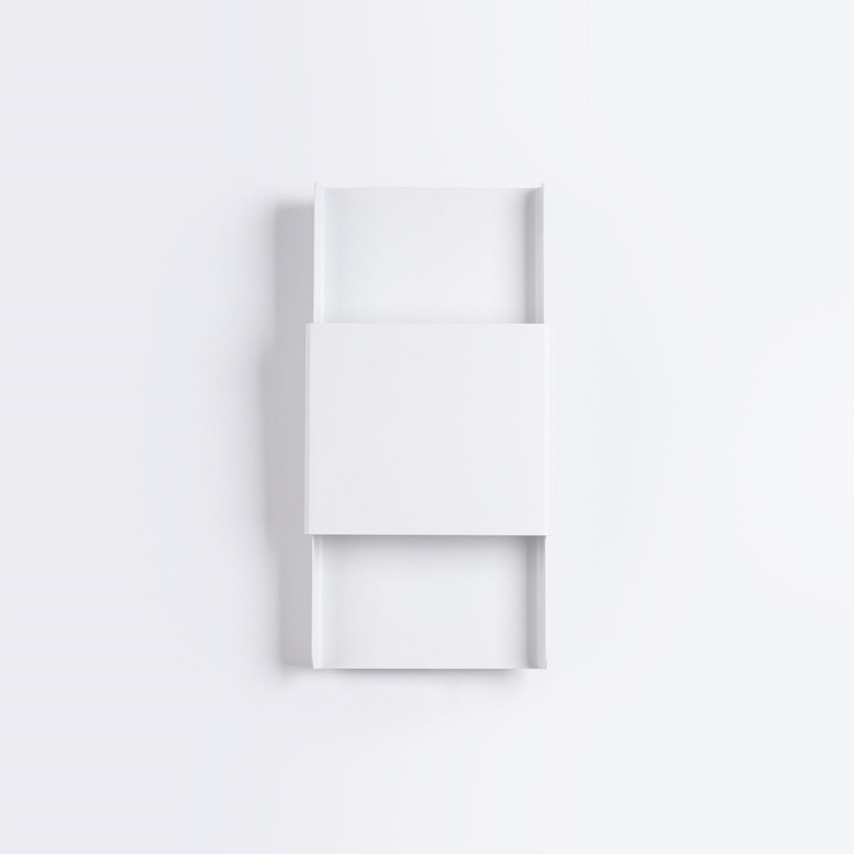 Vue de face de l'applique blanche avec ombre portée sur mur clair, produit non allumé