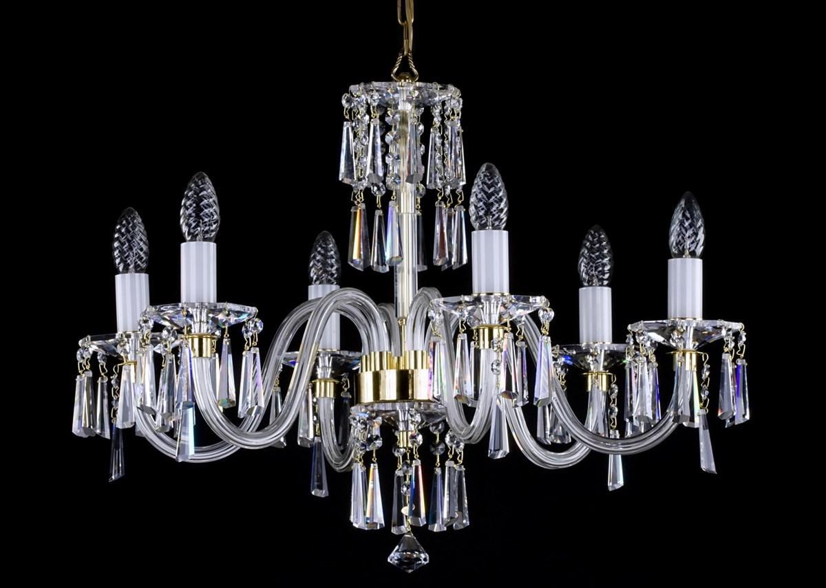 Lustre en cristal à six bras, ampoules flammes et pendeloques, fond noir.