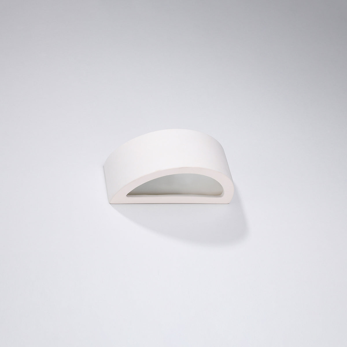Vue trois-quarts de l'applique blanche, ombre douce portée sur fond gris clair