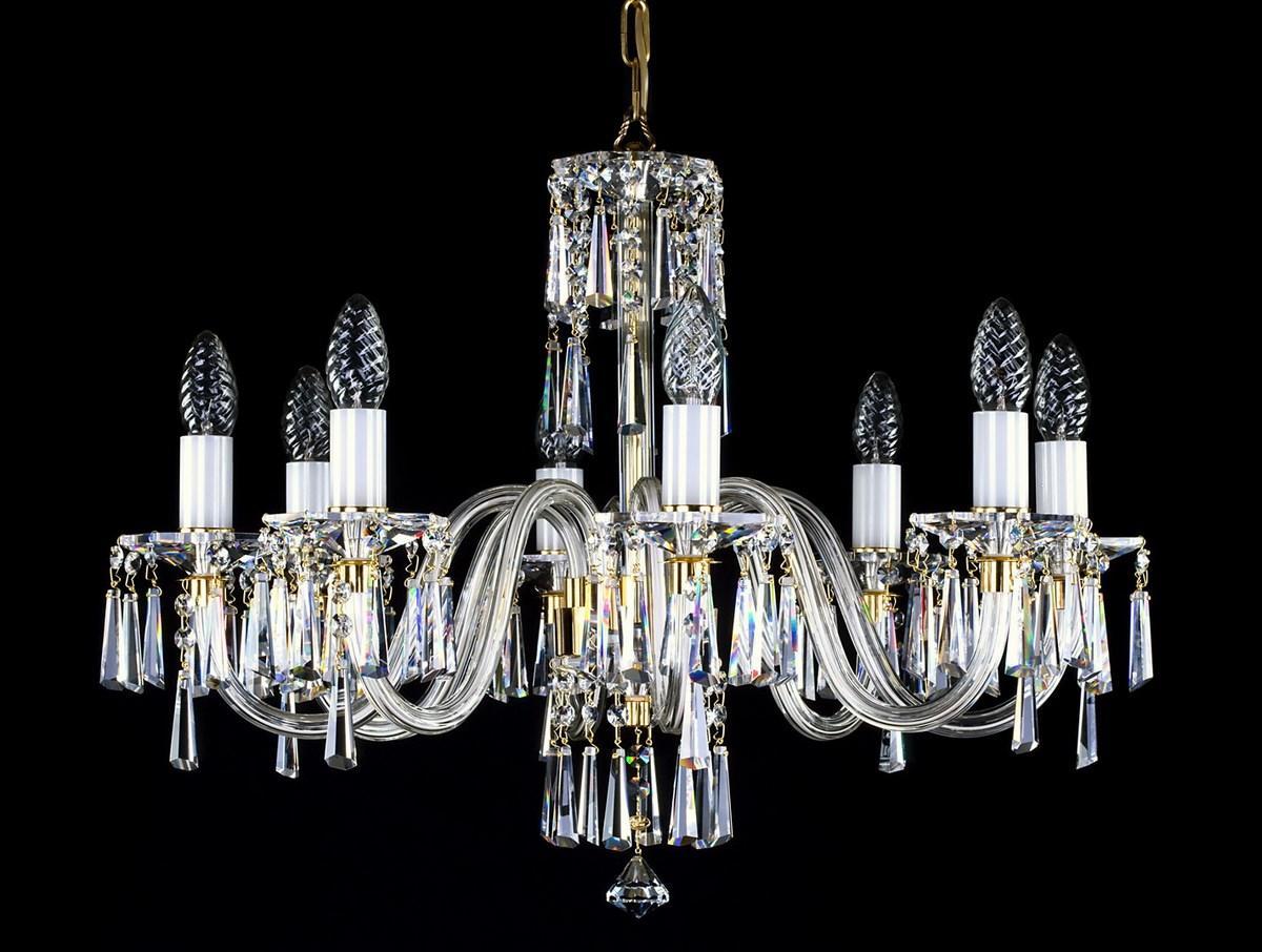 Lustre en cristal de face sur fond noir, bras courbés et pendeloques