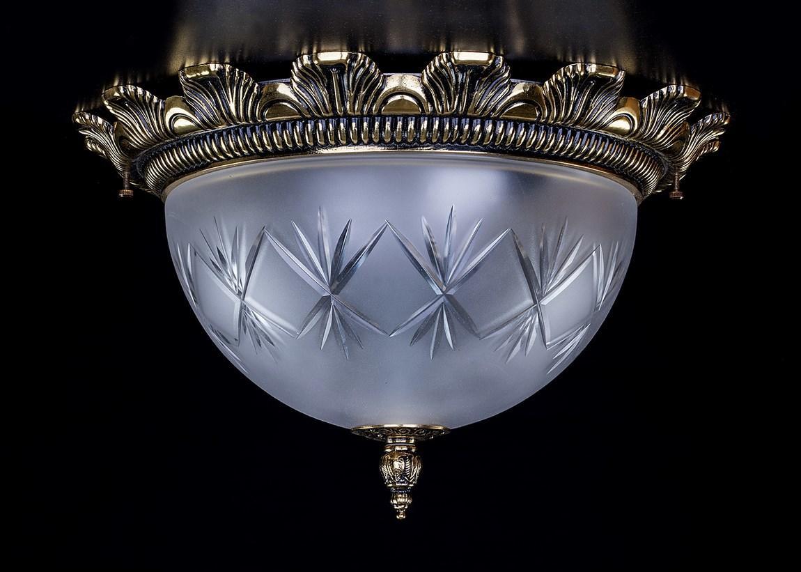 Lustre en laiton et verre dépoli vu de face sur fond noir