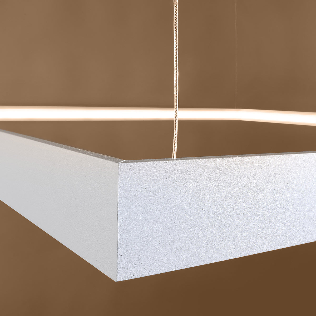 Détail du coin du profilé blanc texturé et du câble tressé