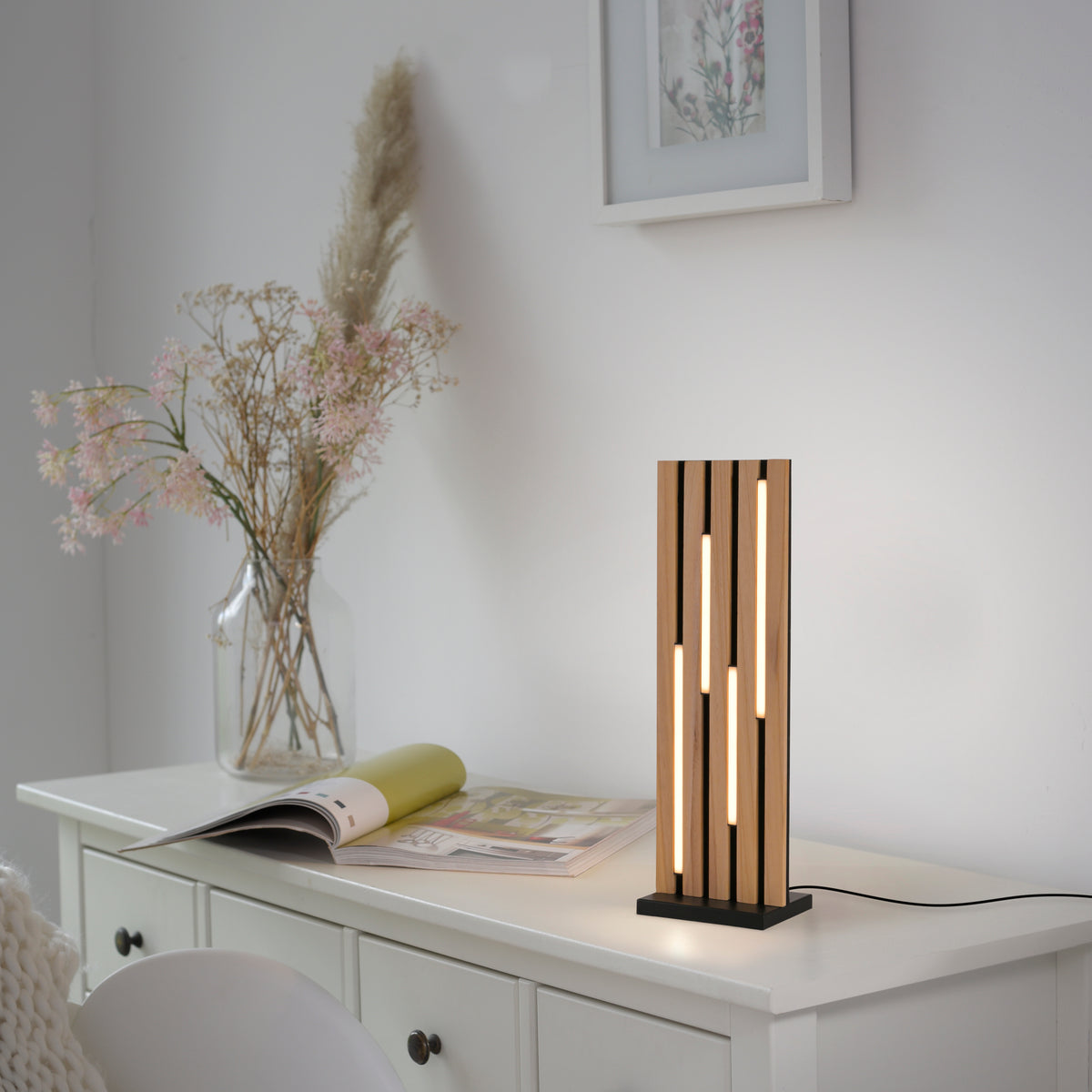 Mise en ambiance sur une commode blanche, bouquet de fleurs séchées à côté