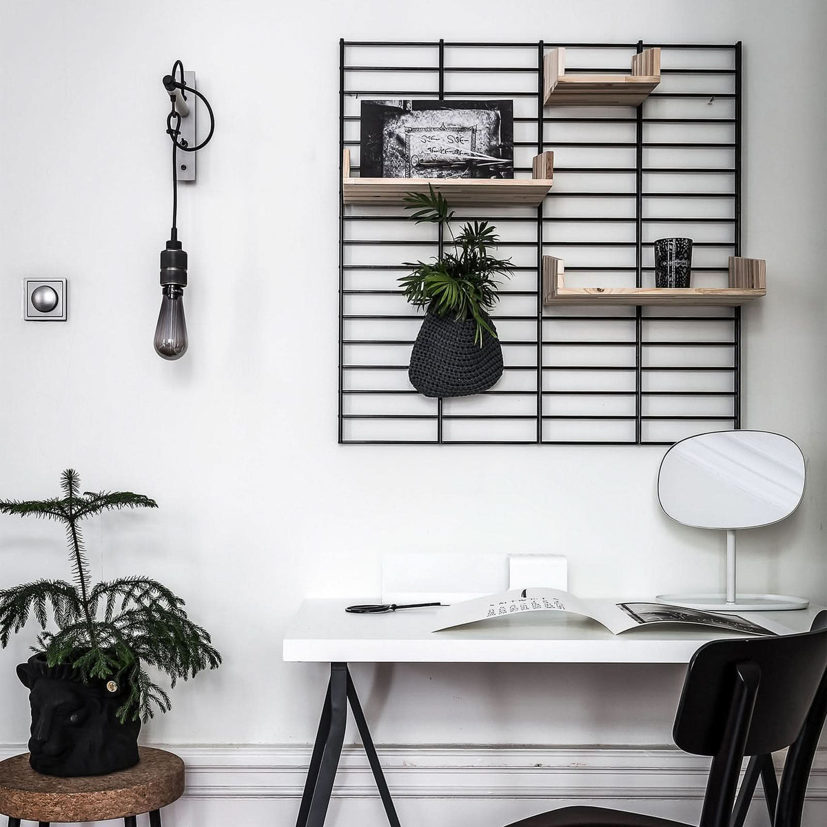Applique murale installée au-dessus d'un bureau blanc avec étagère métallique à droite.