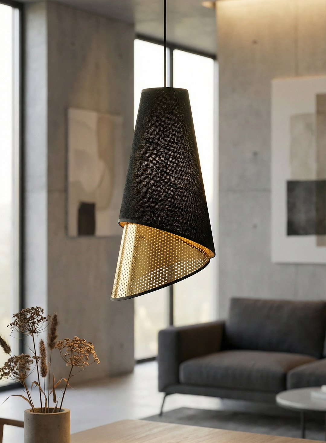 Détail d'un abat-jour conique noir en tissu, intérieur doré perforé, suspendu.