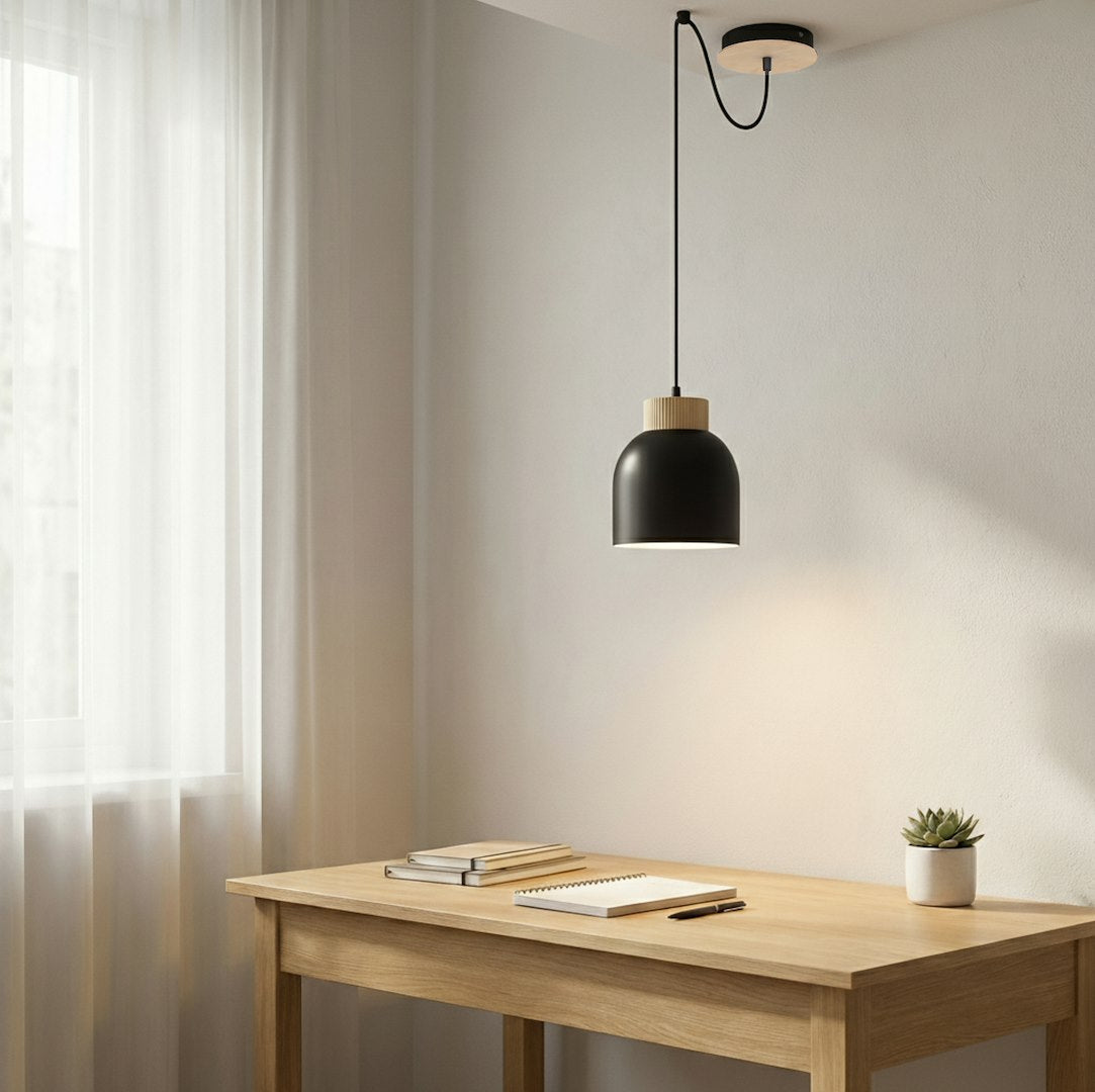 Ambiance bureau clair, suspension noire éclairant une table en bois devant la fenêtre