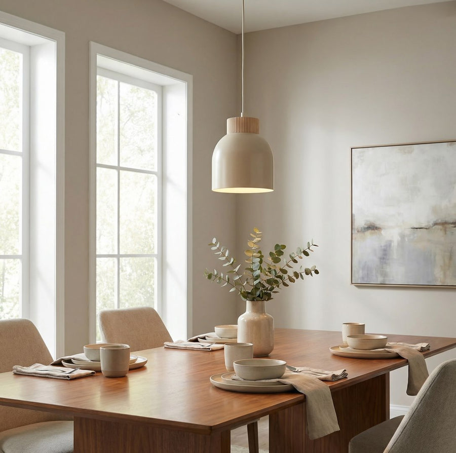 Suspension beige éclairée au-dessus d'une table dressée avec vase d'eucalyptus