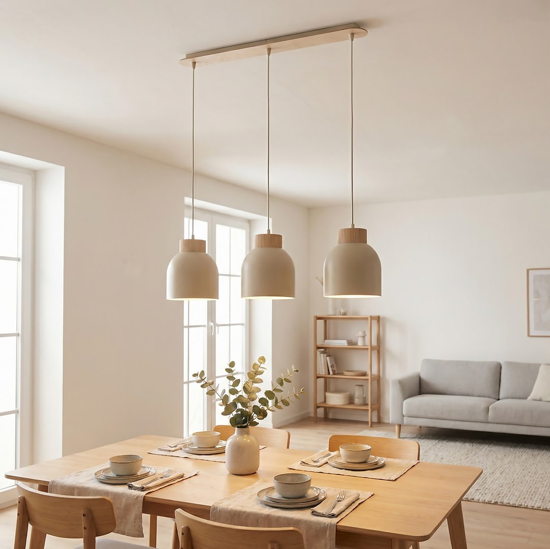 Salle à manger lumineuse avec suspension trois abat-jours beiges au-dessus table en bois