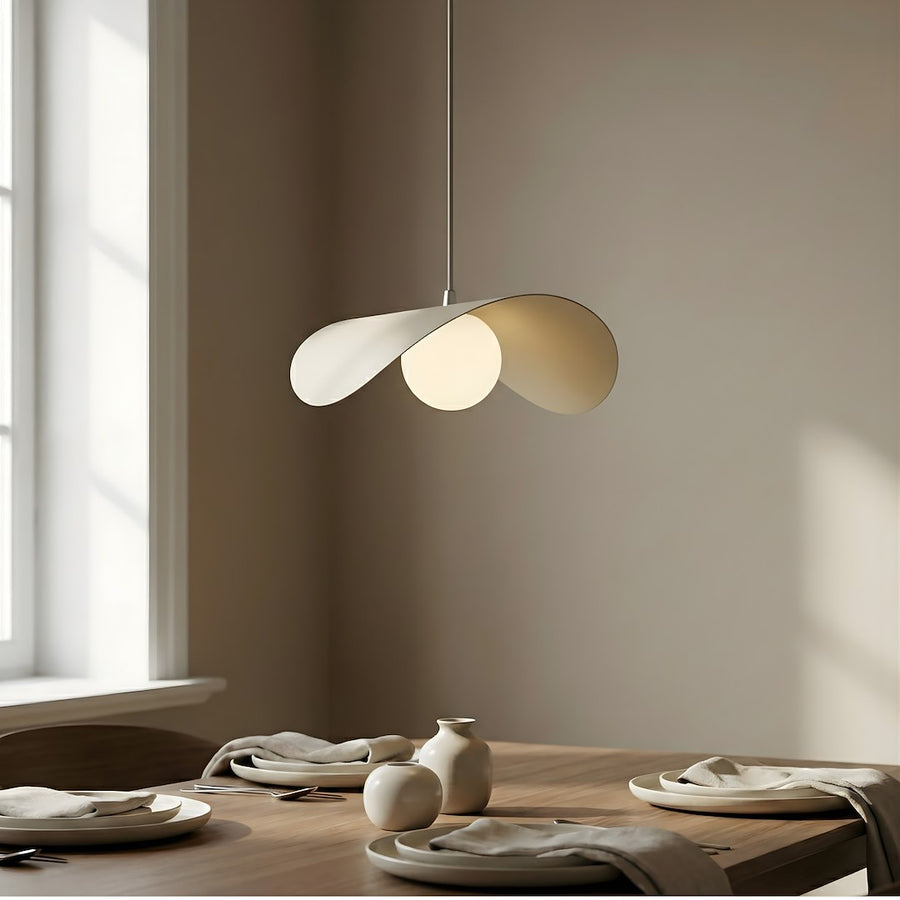 Gros plan sur la suspension éclairée au-dessus d'une table dressée près d'une fenêtre.