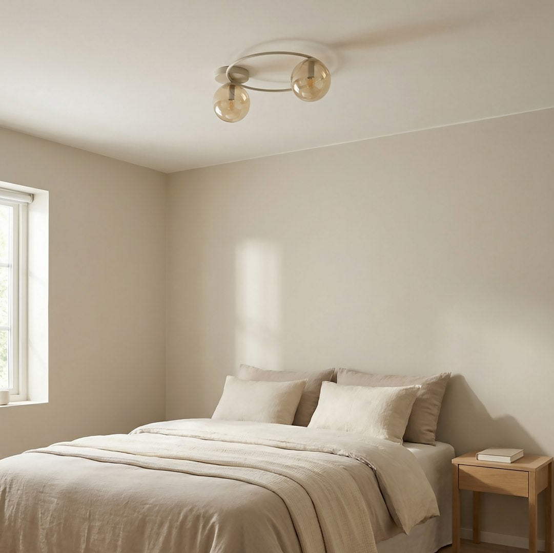 Mise en ambiance dans une chambre beige, luminaire allumé au-dessus du lit