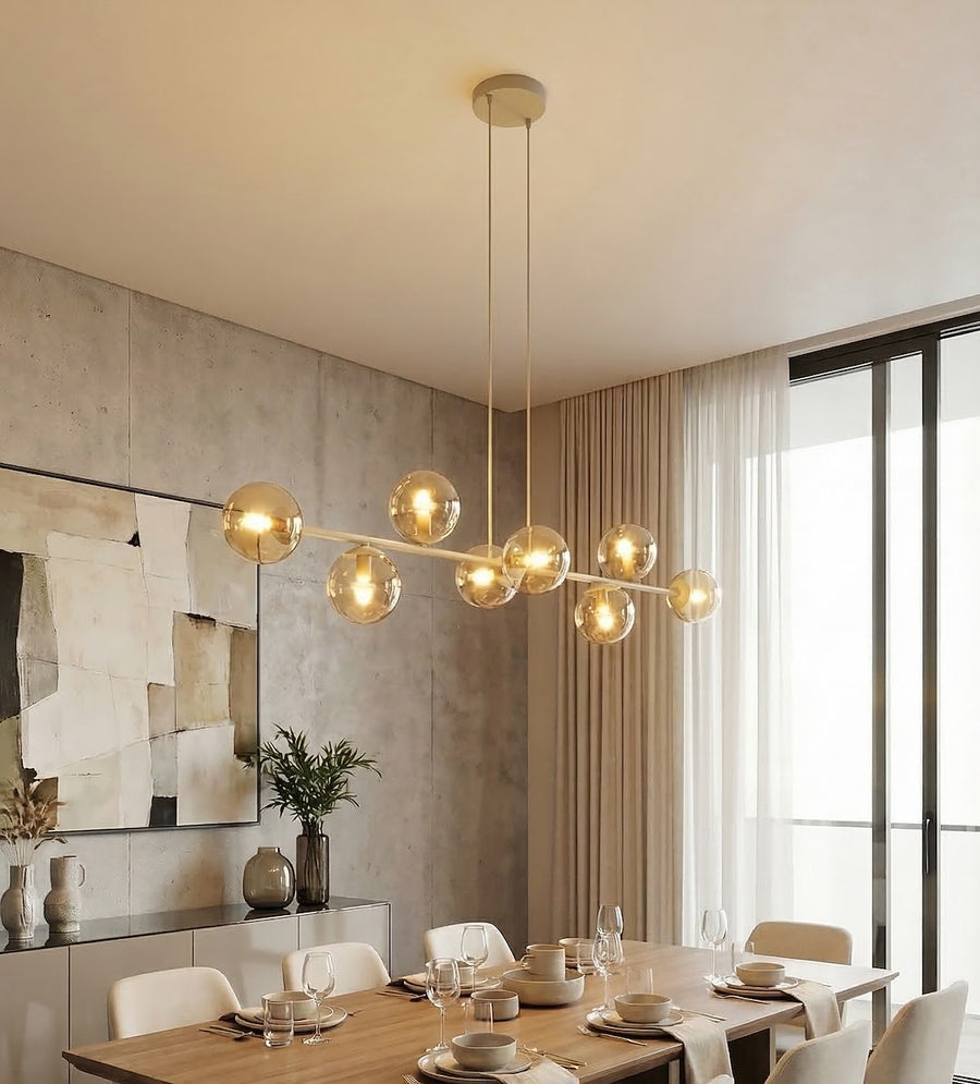 Suspension éclairée dans une salle à manger contemporaine, mur béton et baie vitrée.