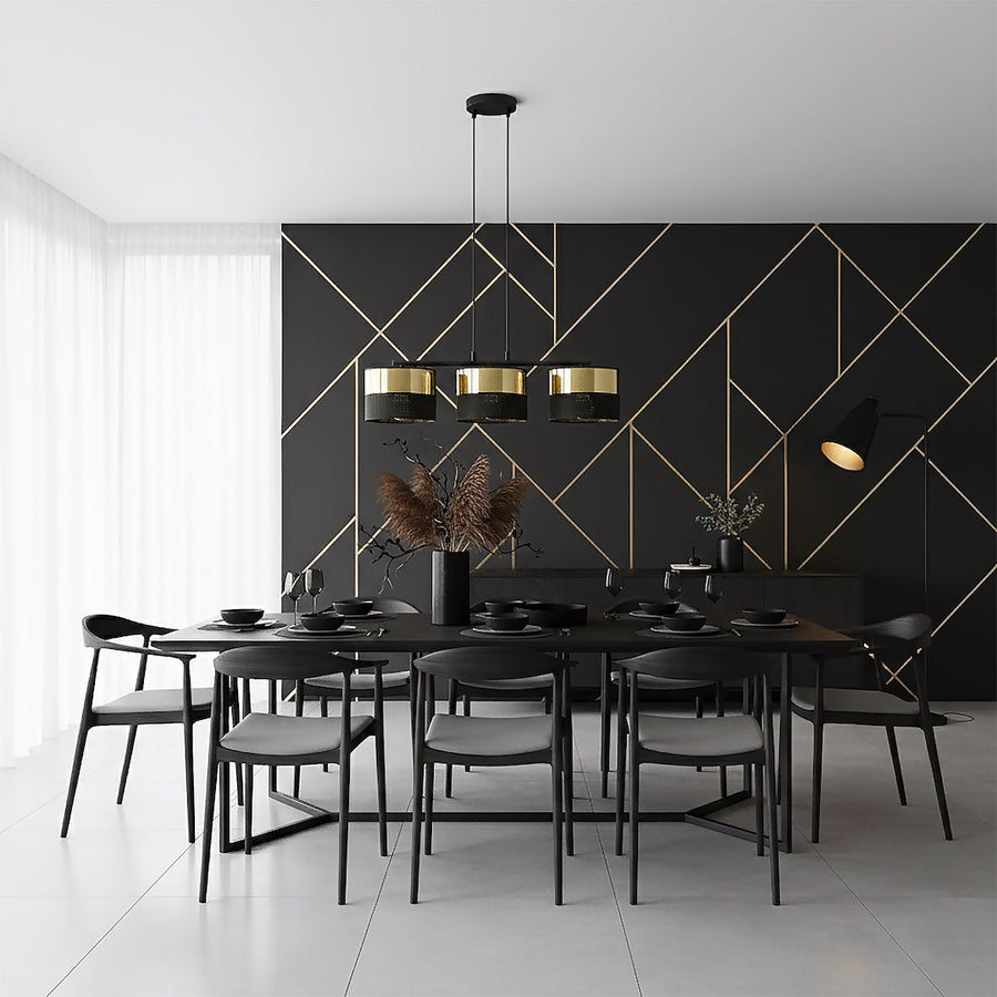 Ambiance salle à manger au mur noir géométrique doré, suspension au-dessus de la table dressée.